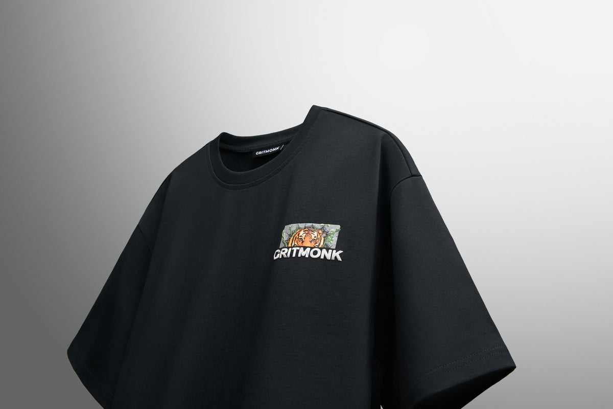GRITMONK APEX black oversized tee: angled front view, chest print