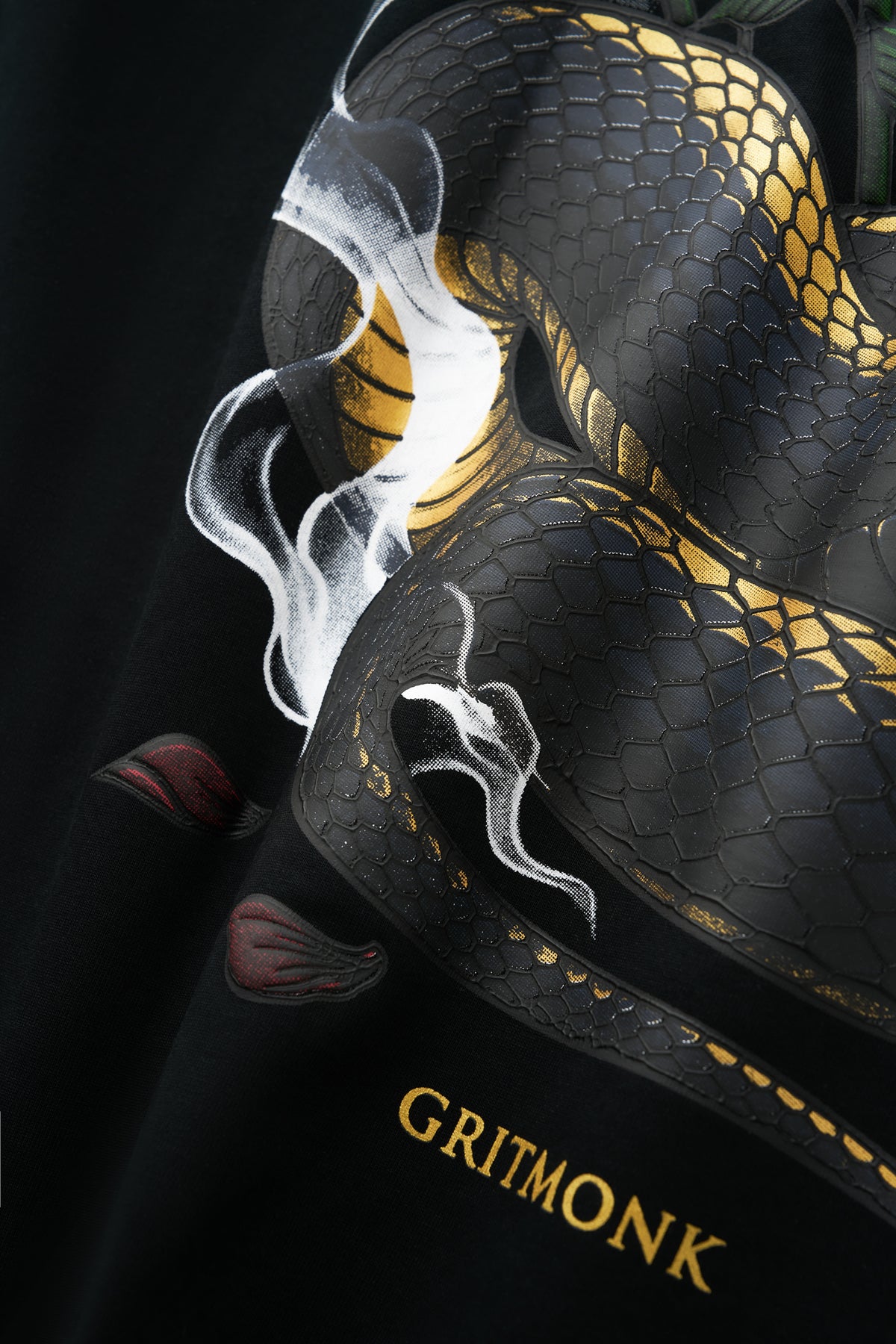 GRITMONK VENOM black oversized tee: close-up of the smoke and gold GRITMONK wordmark